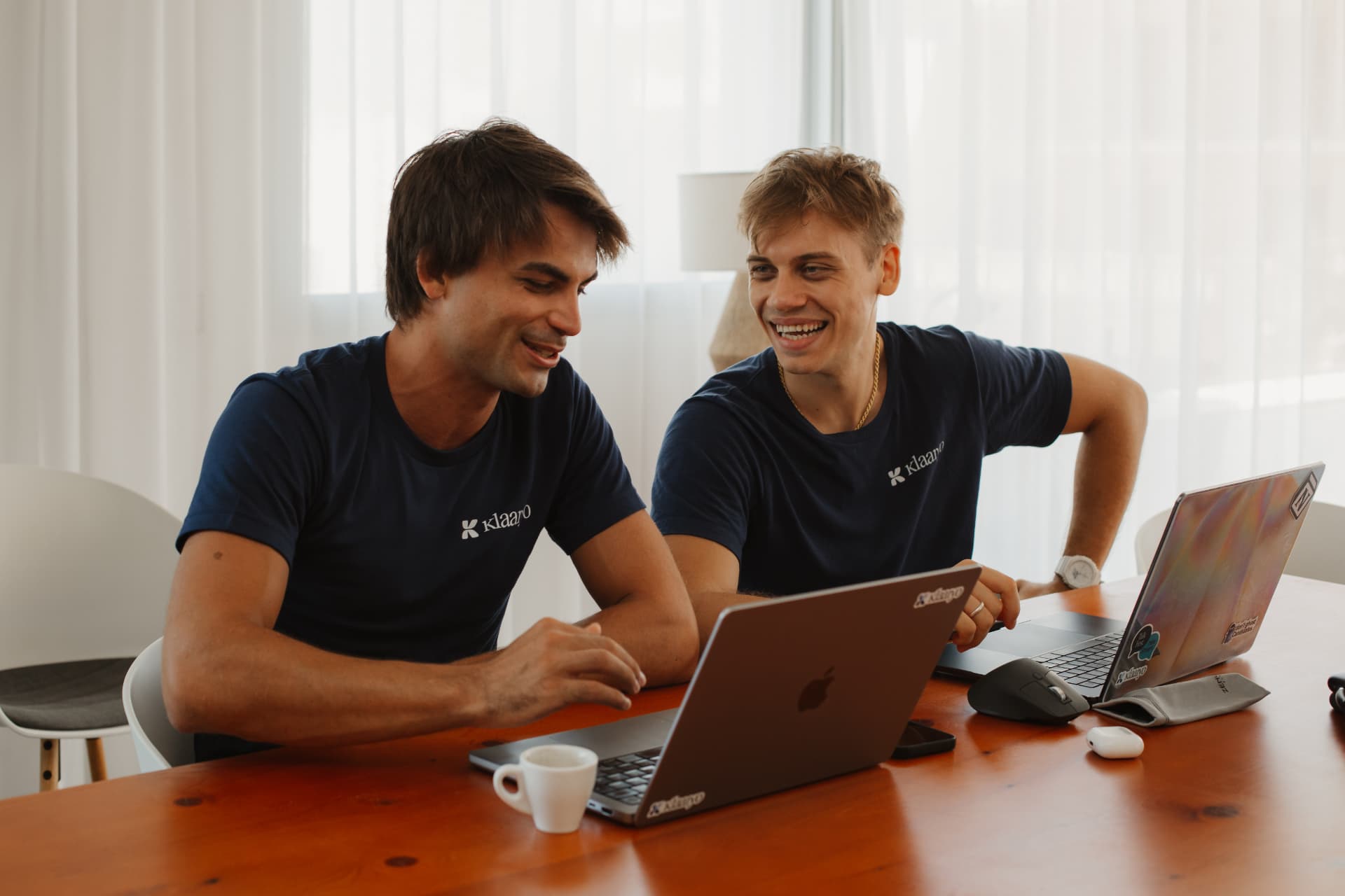 Due colleghi Klaaryo sorridono davanti al laptop
