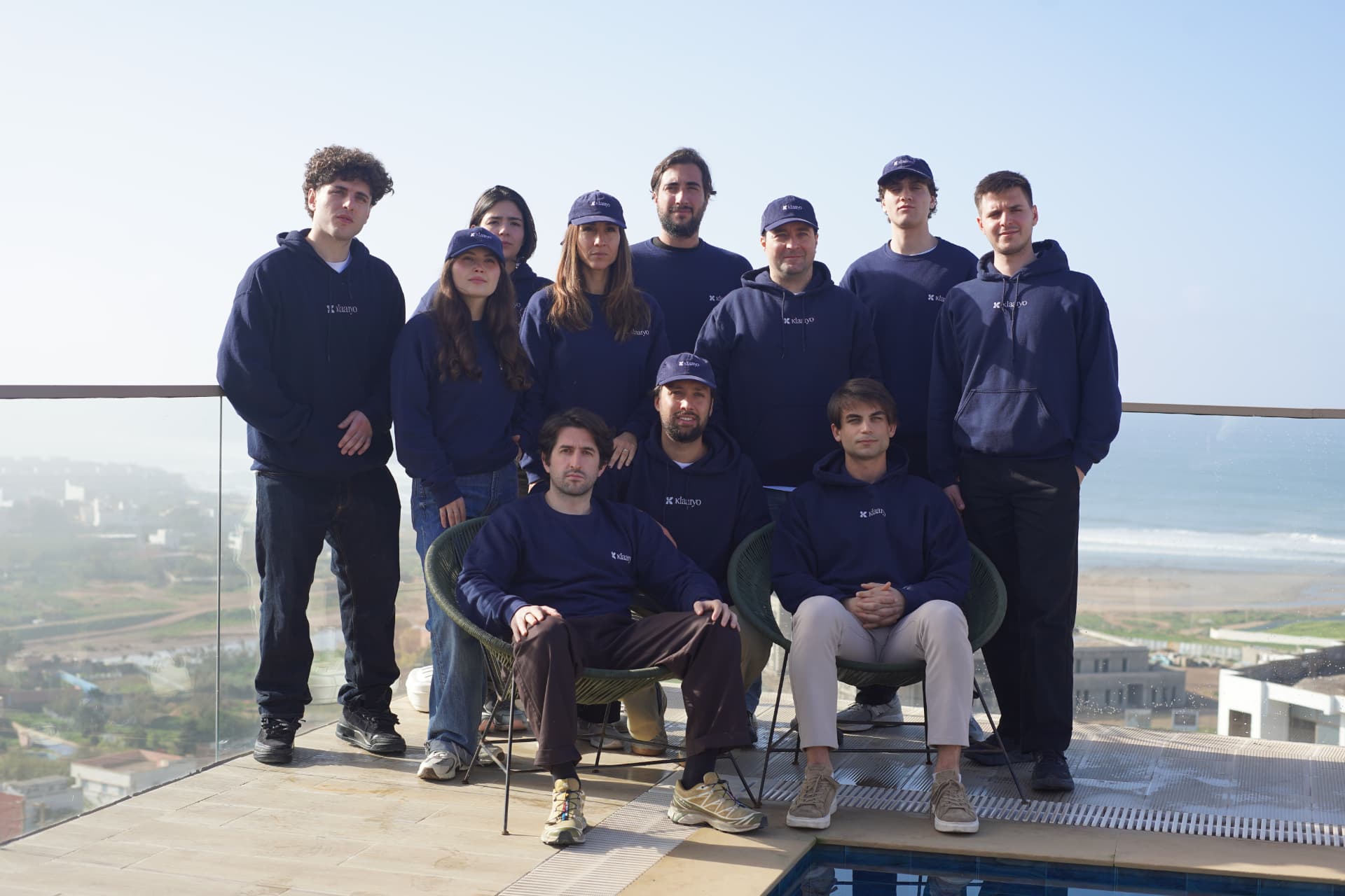 Foto di gruppo del team Klaaryo sulla terrazza vista oceano
