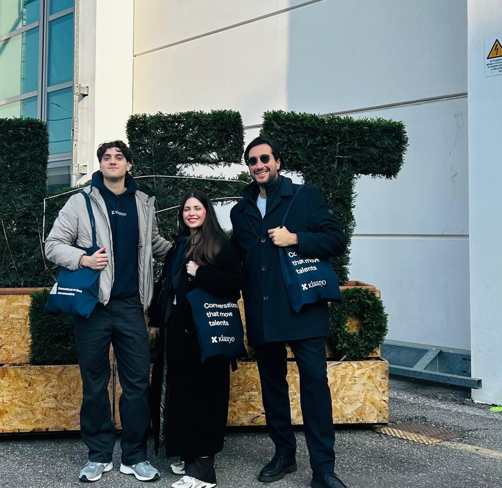 Tre persone del team Klaaryo a un evento di settore con le tote bag brandizzate
